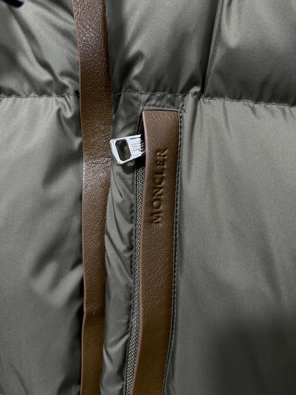 Puffer jacket zipper with Moncler logo fabric tab and leather-look pull strap
