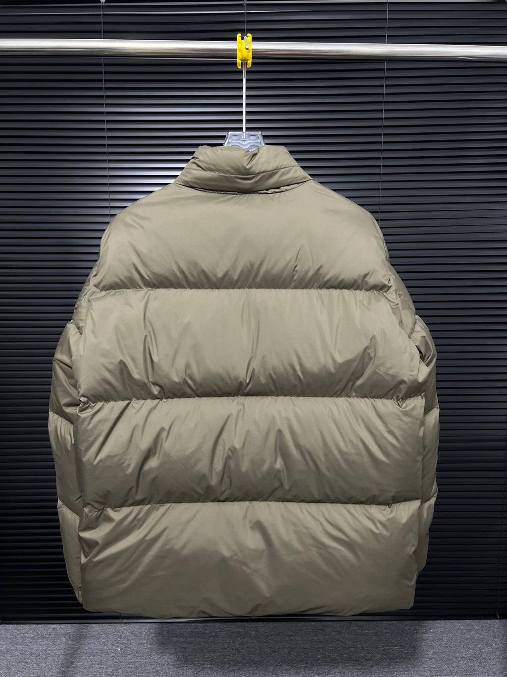Long puffer jacket back view with hood, hanging on a hanger