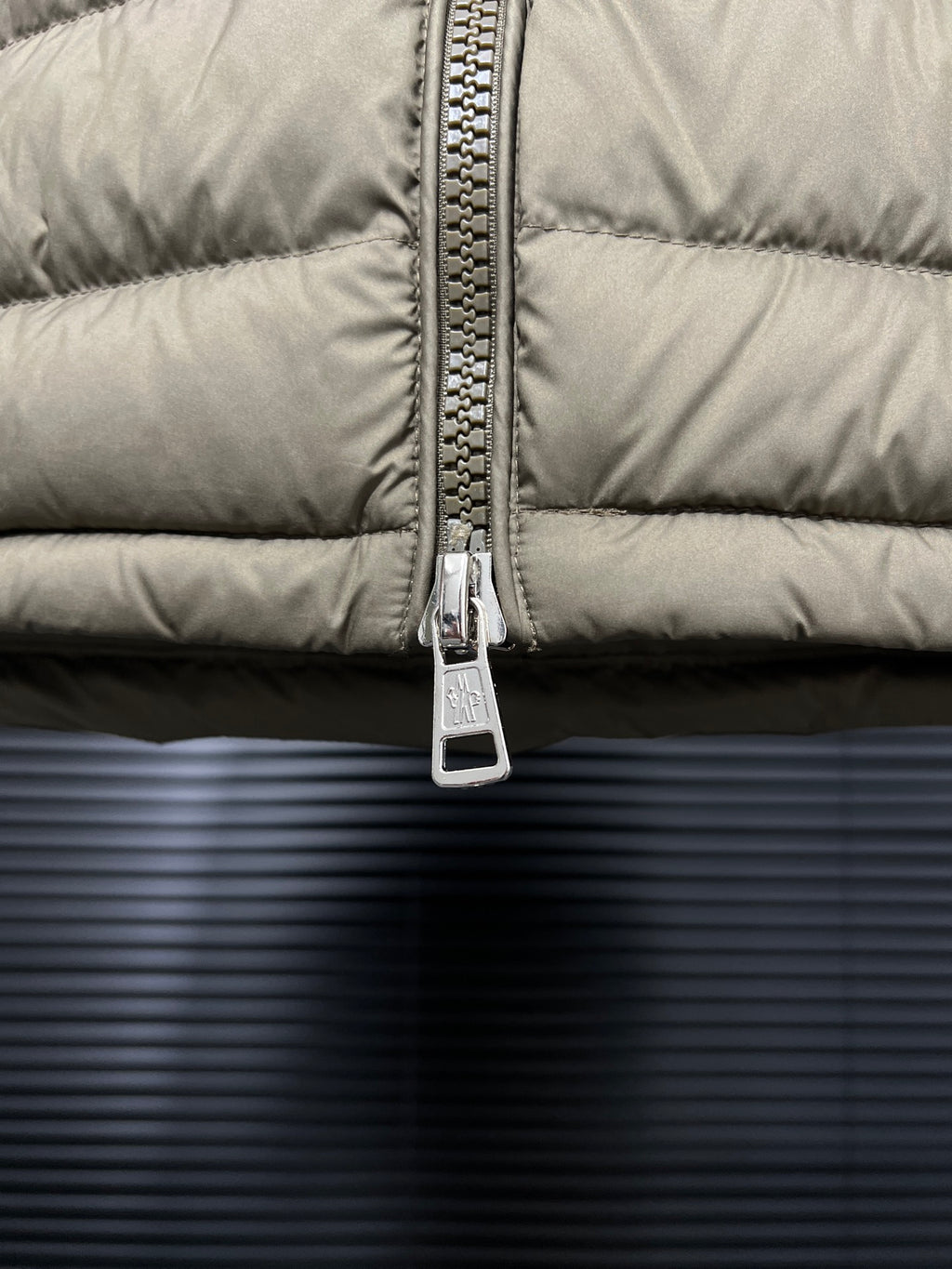 Olive puffer jacket front zipper and metal pull
