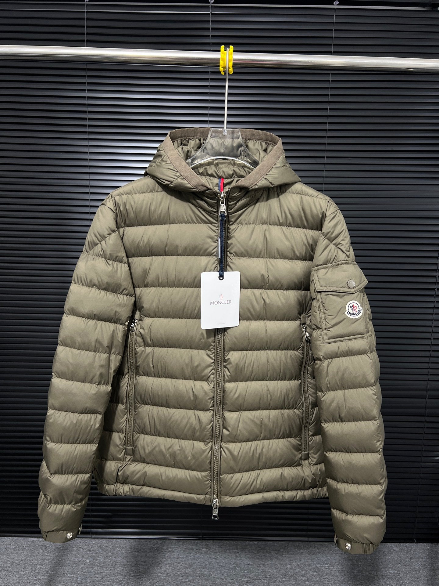 Olive hooded puffer jacket with full front zipper and side logo patch
