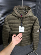Olive hooded puffer jacket with front zipper and hang tag