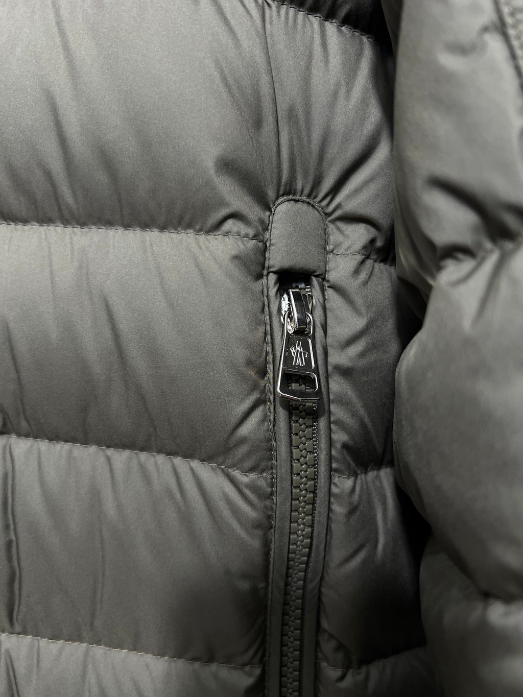Olive puffer jacket zipper detail with snap trim