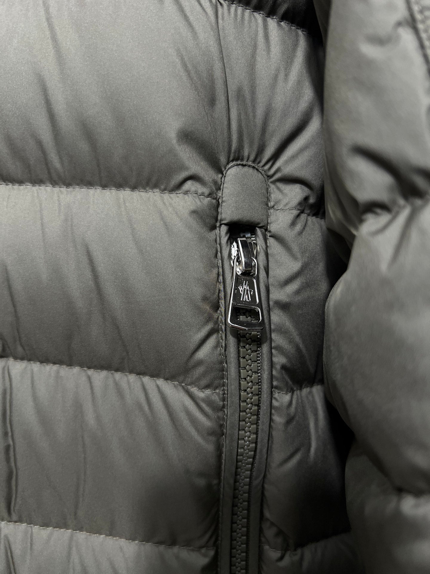 Olive puffer jacket zipper detail with snap trim