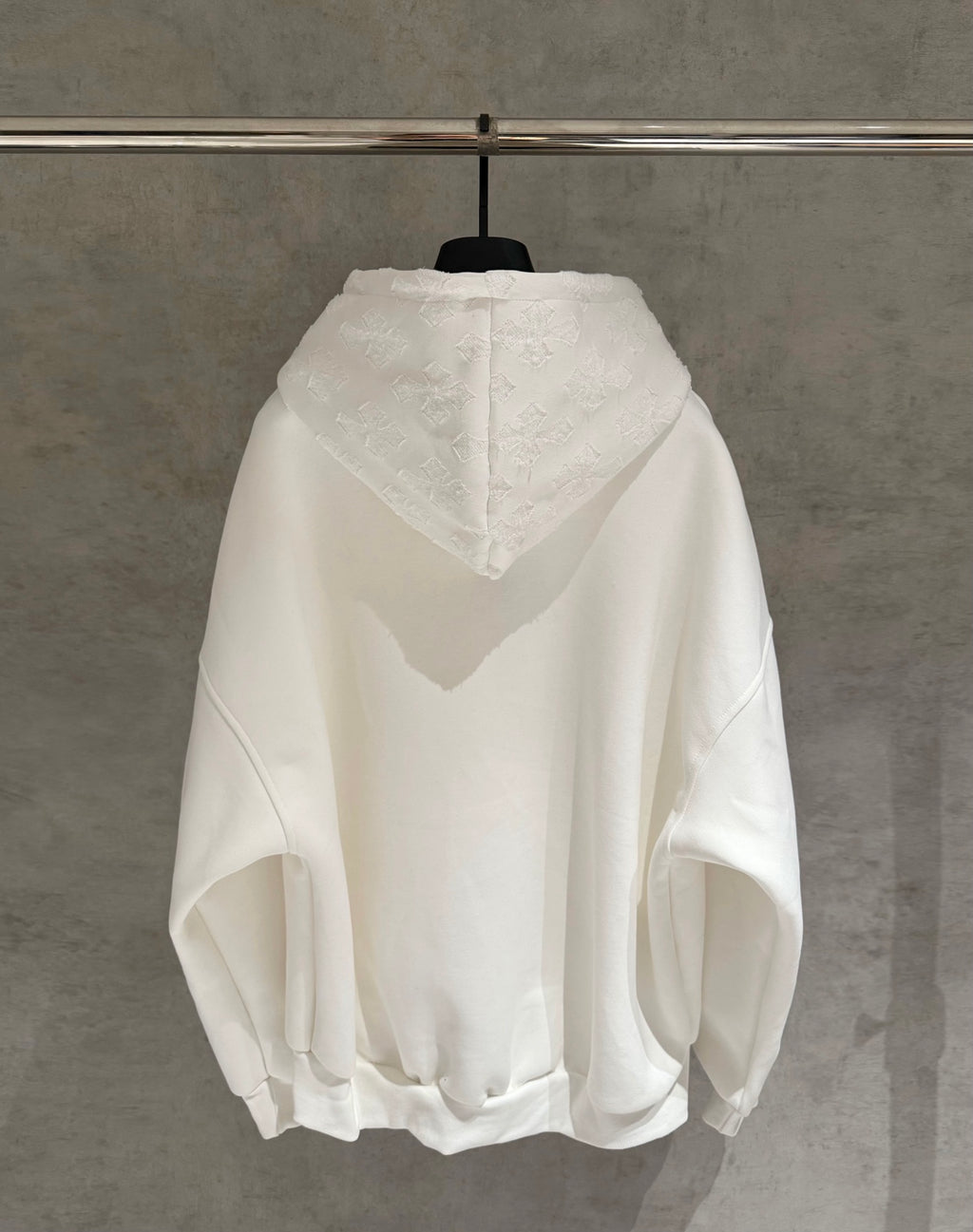 White zip-up hoodie with hood and large textured back logo