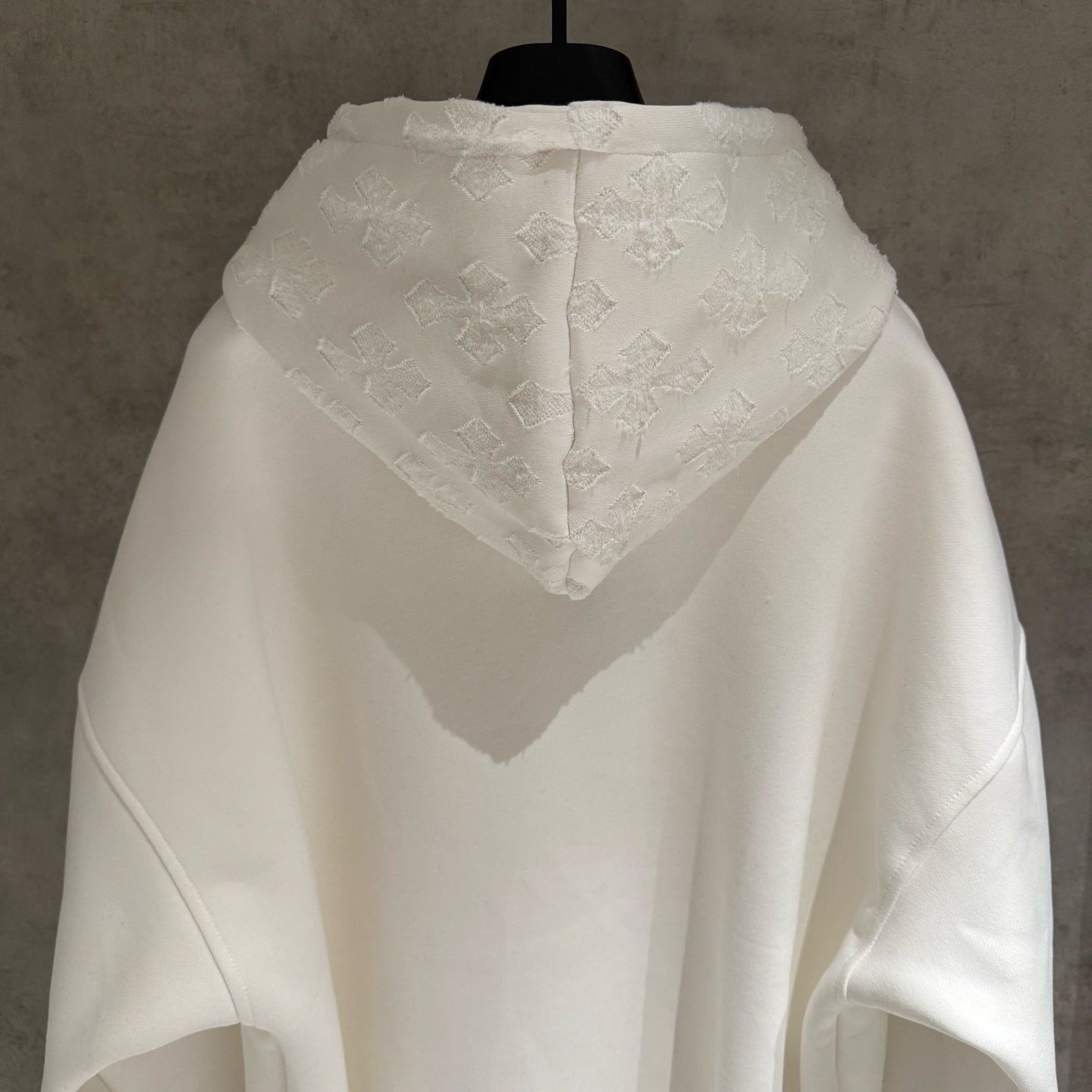 White zip-up hoodie with hood and textured back yoke logo