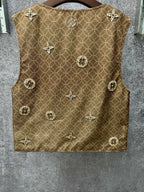 Gold monogram sleeveless vest with decorative medallions, back view close-up