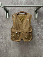 Gold monogram sleeveless vest with zip front, flap pockets, decorative charm buttons