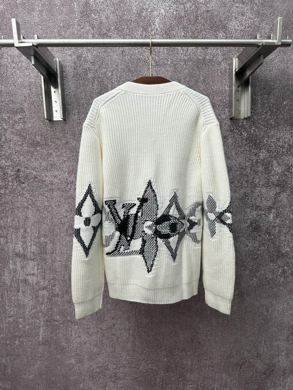 Cream knit cardigan with black butterfly-style motif embroidery across the back