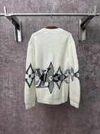 Cream knit cardigan with black butterfly-style motif embroidery across the back