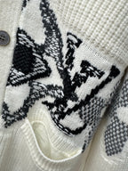 Cream knit cardigan close-up of black butterfly-style motif embroidery and buttons
