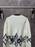 Back of cream knit cardigan with black butterfly-style motif band across the hem