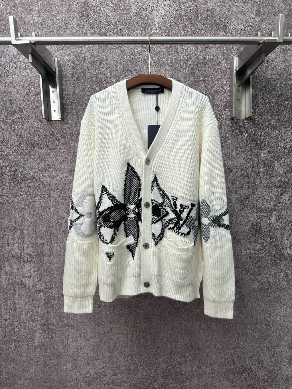 Cream knit cardigan with black patterned butterfly-style motifs and button front