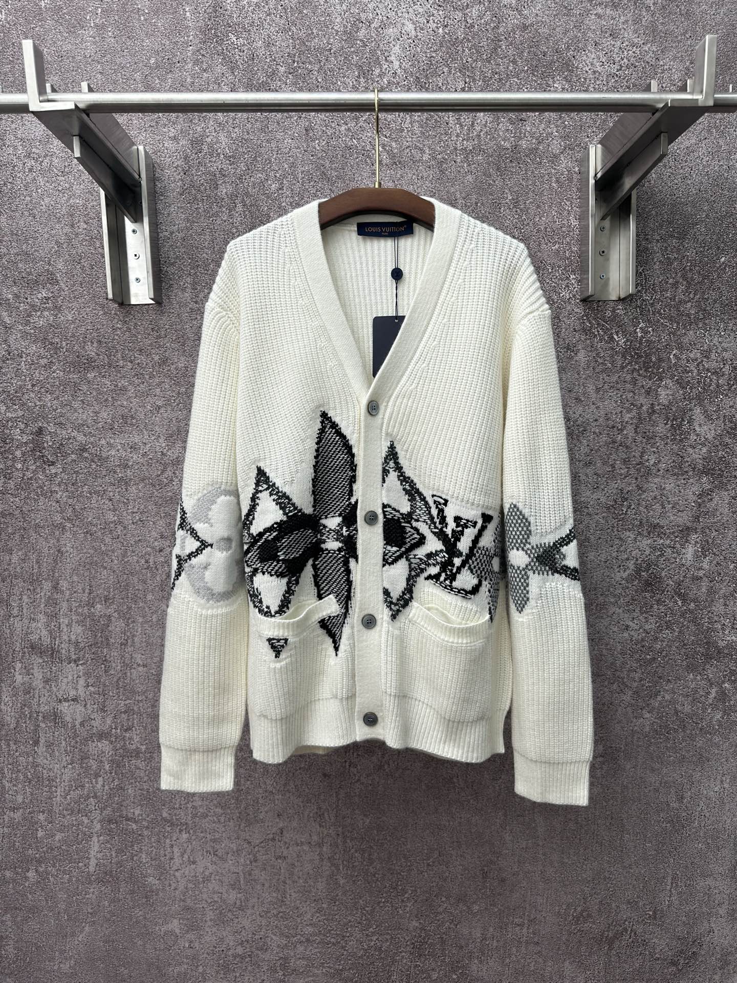 Cream knit cardigan with black patterned butterfly-style motifs and button front