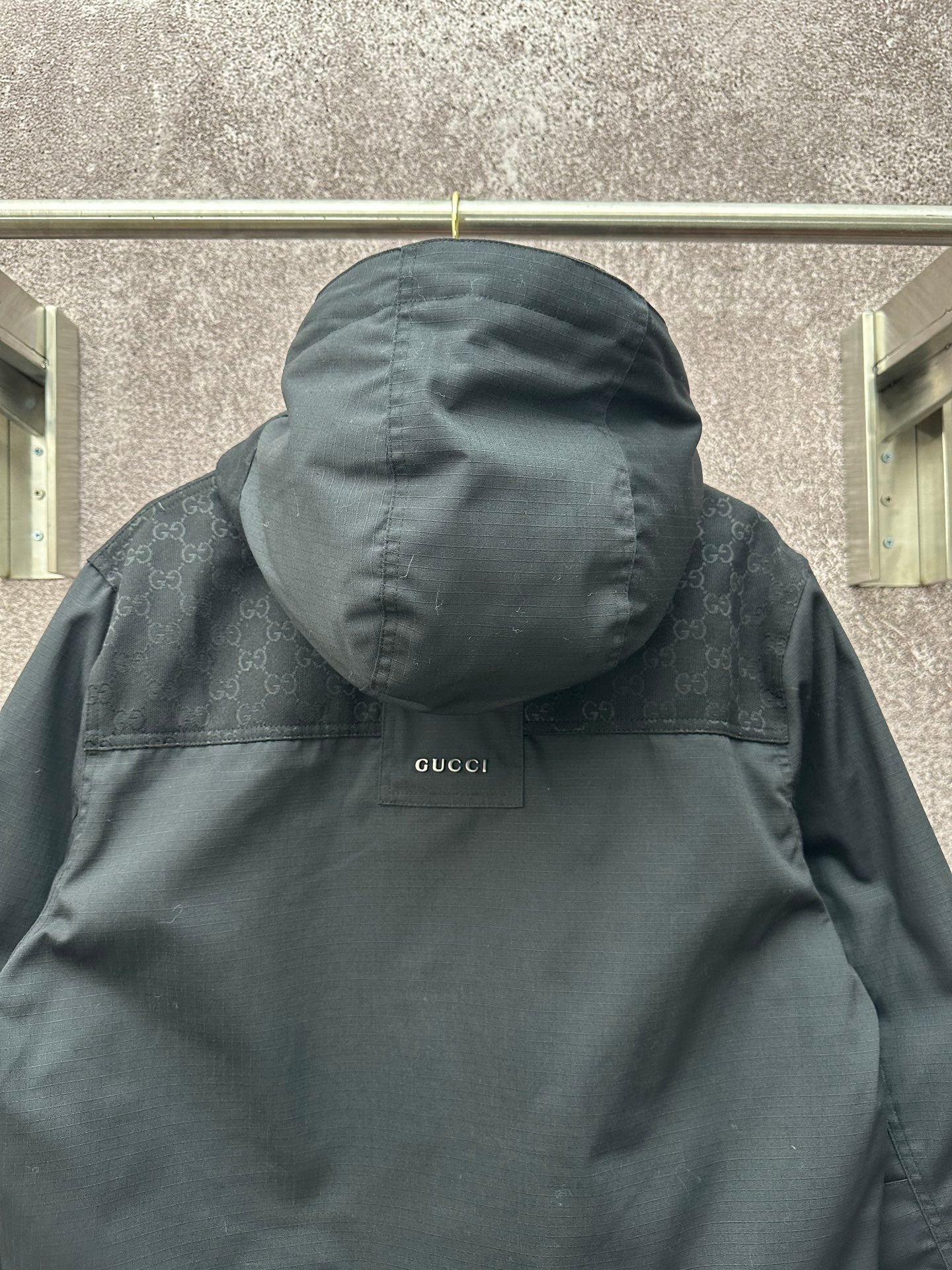 Dark Gucci hooded jacket with Gucci label on back