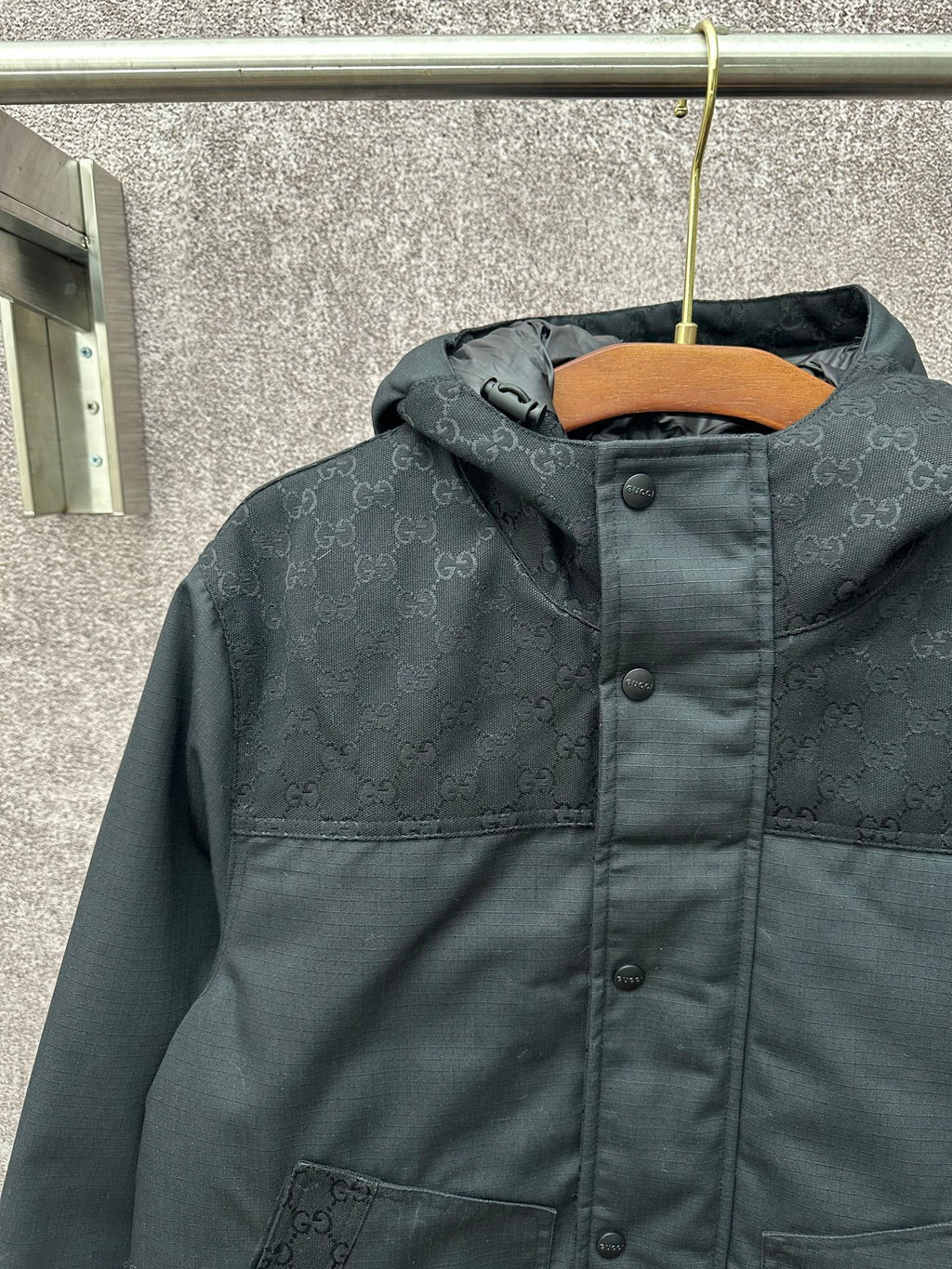 Dark hooded jacket with front panel and buttoned placket