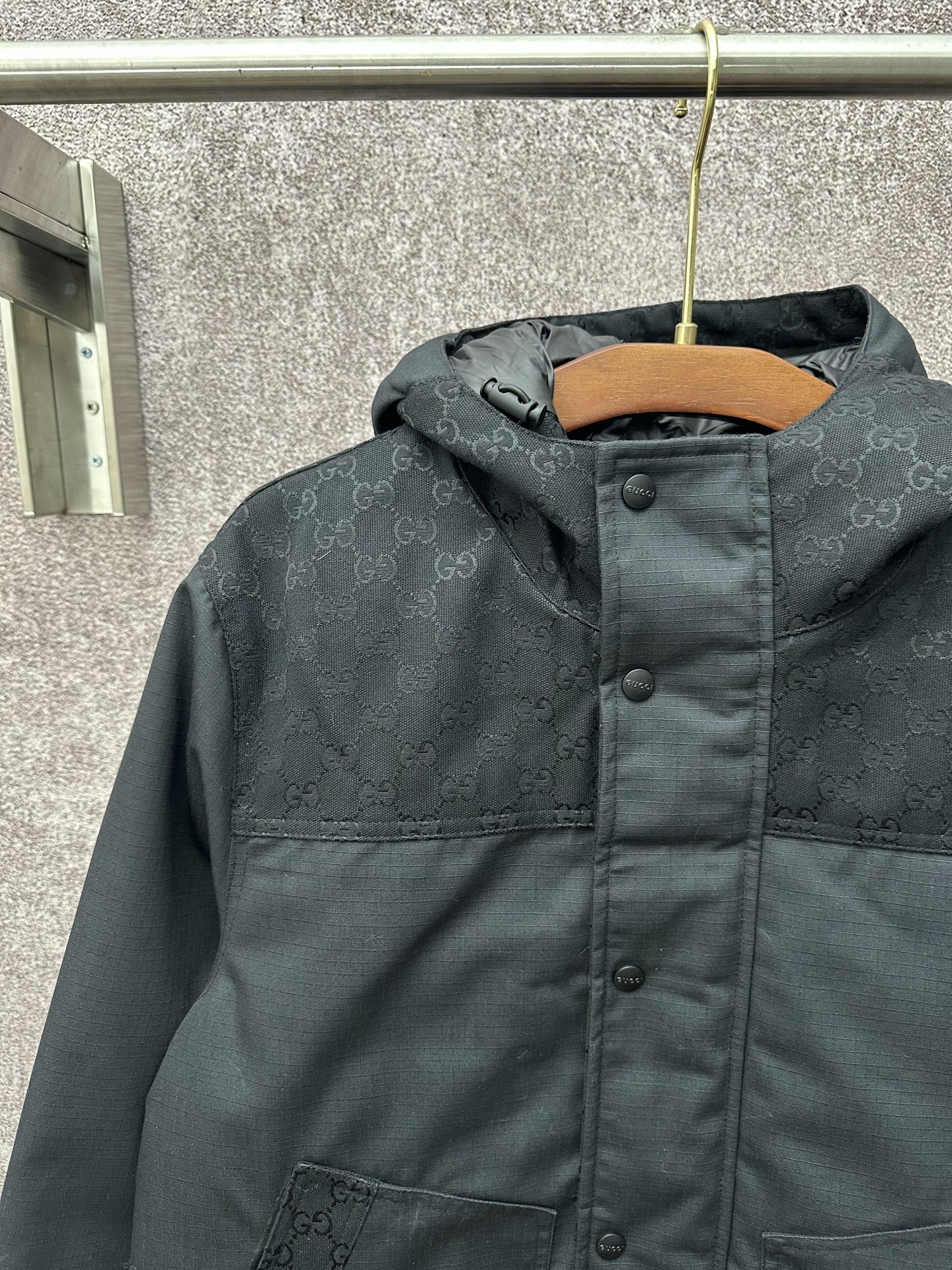 Dark hooded jacket with front panel and buttoned placket