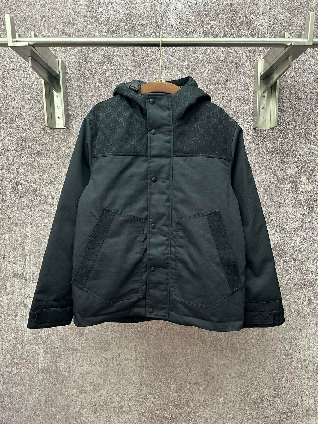 Dark hooded jacket with front button placket and two chest pockets