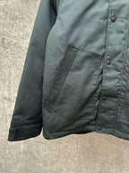 Dark jacket sleeve and front pocket with monogram trim and snap buttons