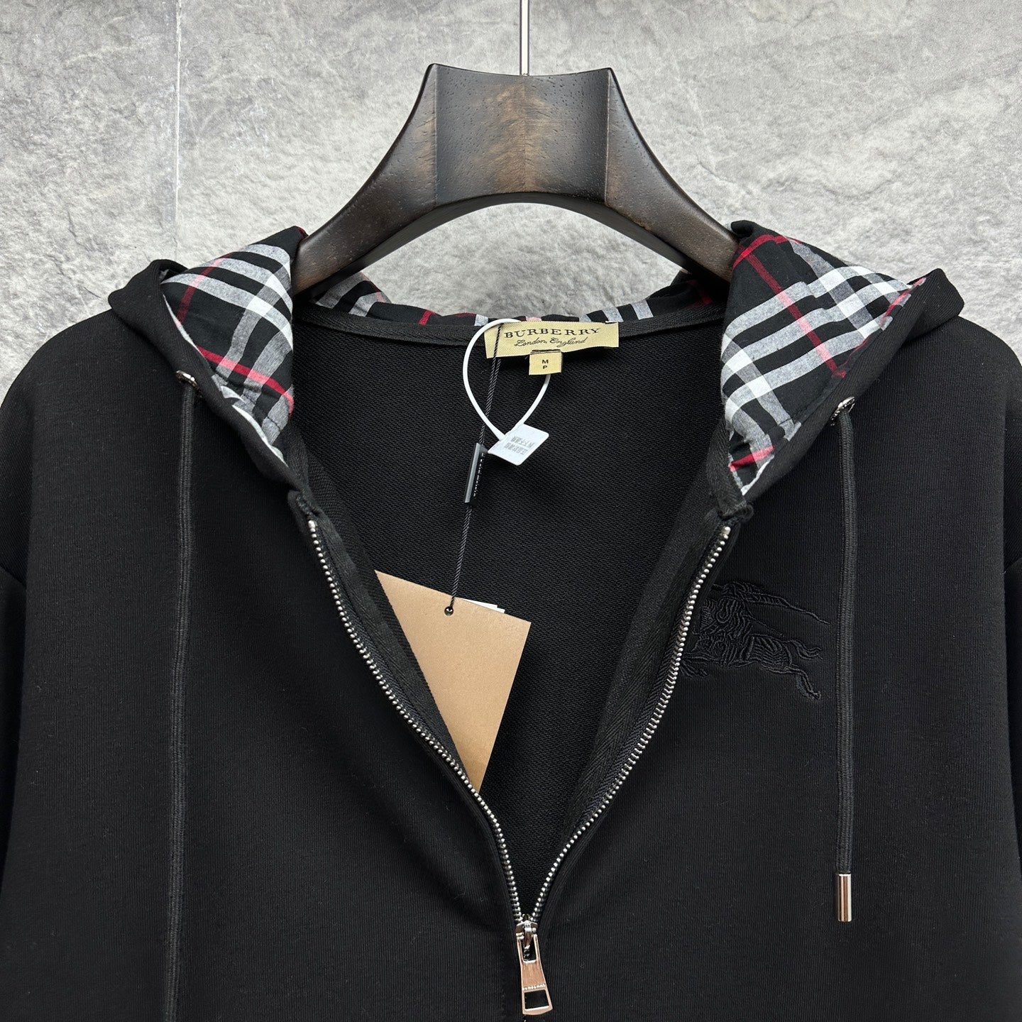 Burberry zip-up hoodie, black, hood open showing plaid lining and drawstring cords