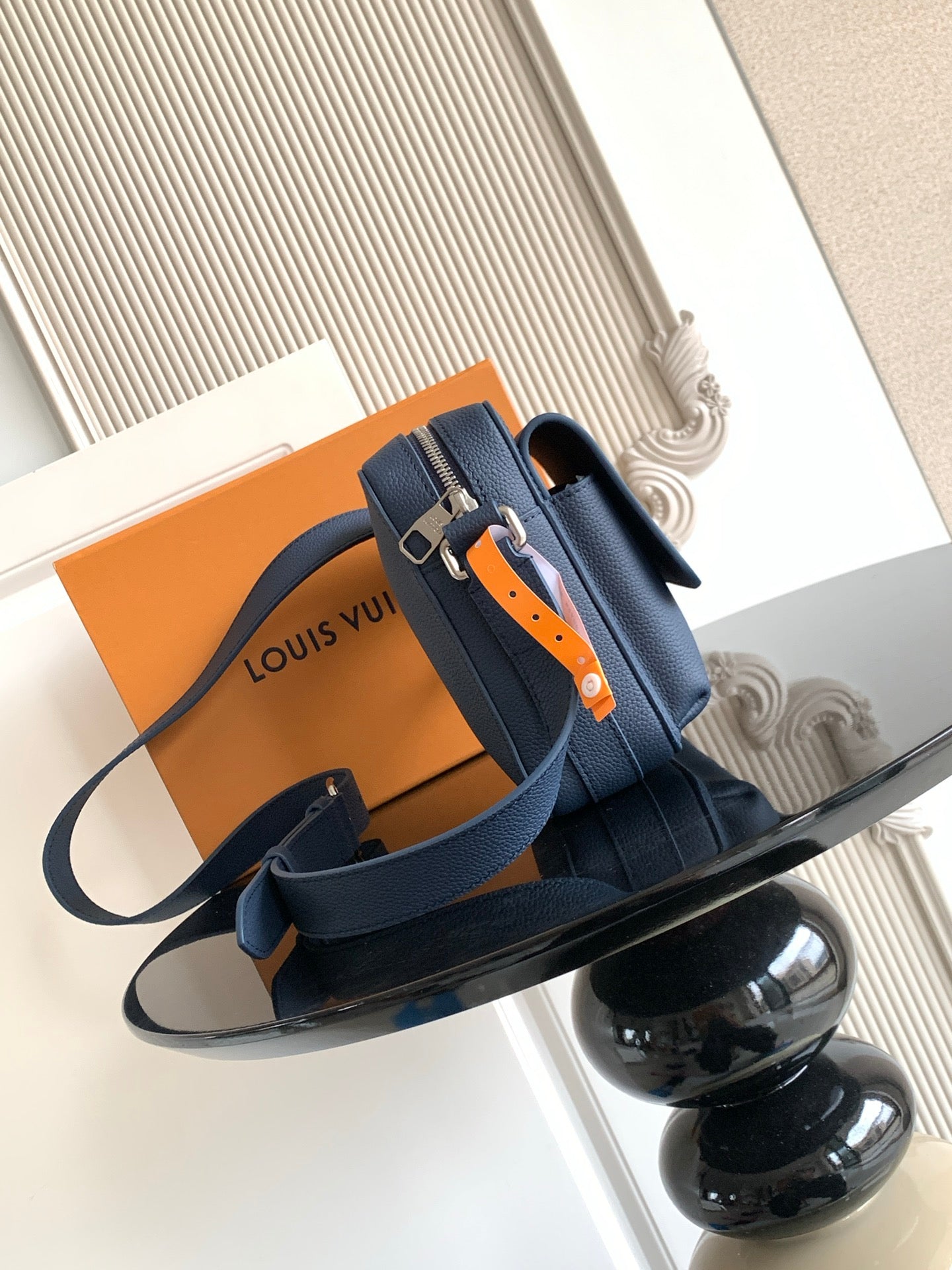 Blue crossbody bag with adjustable shoulder strap and Louis Vuitton logo strap hardware
