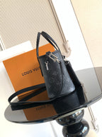 Louis Vuitton mini handbag with top handle, strap loop, and monogram pattern