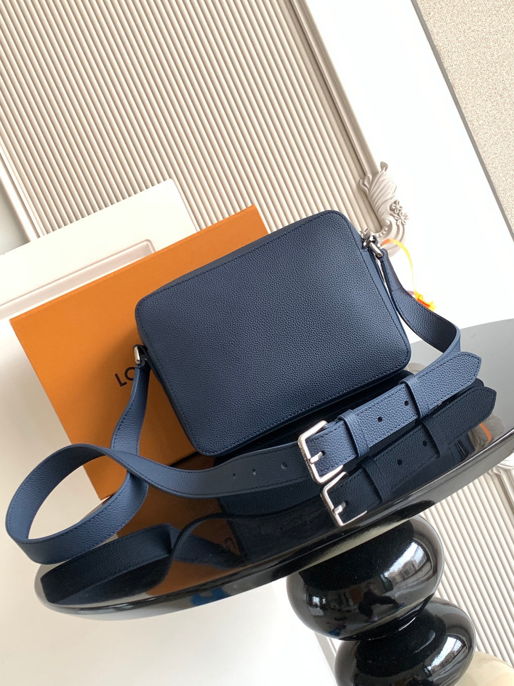 Blue crossbody bag with flap front, top zipper, and adjustable shoulder strap