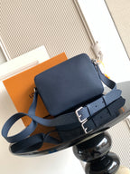 Blue crossbody bag with flap front, top zipper, and adjustable shoulder strap