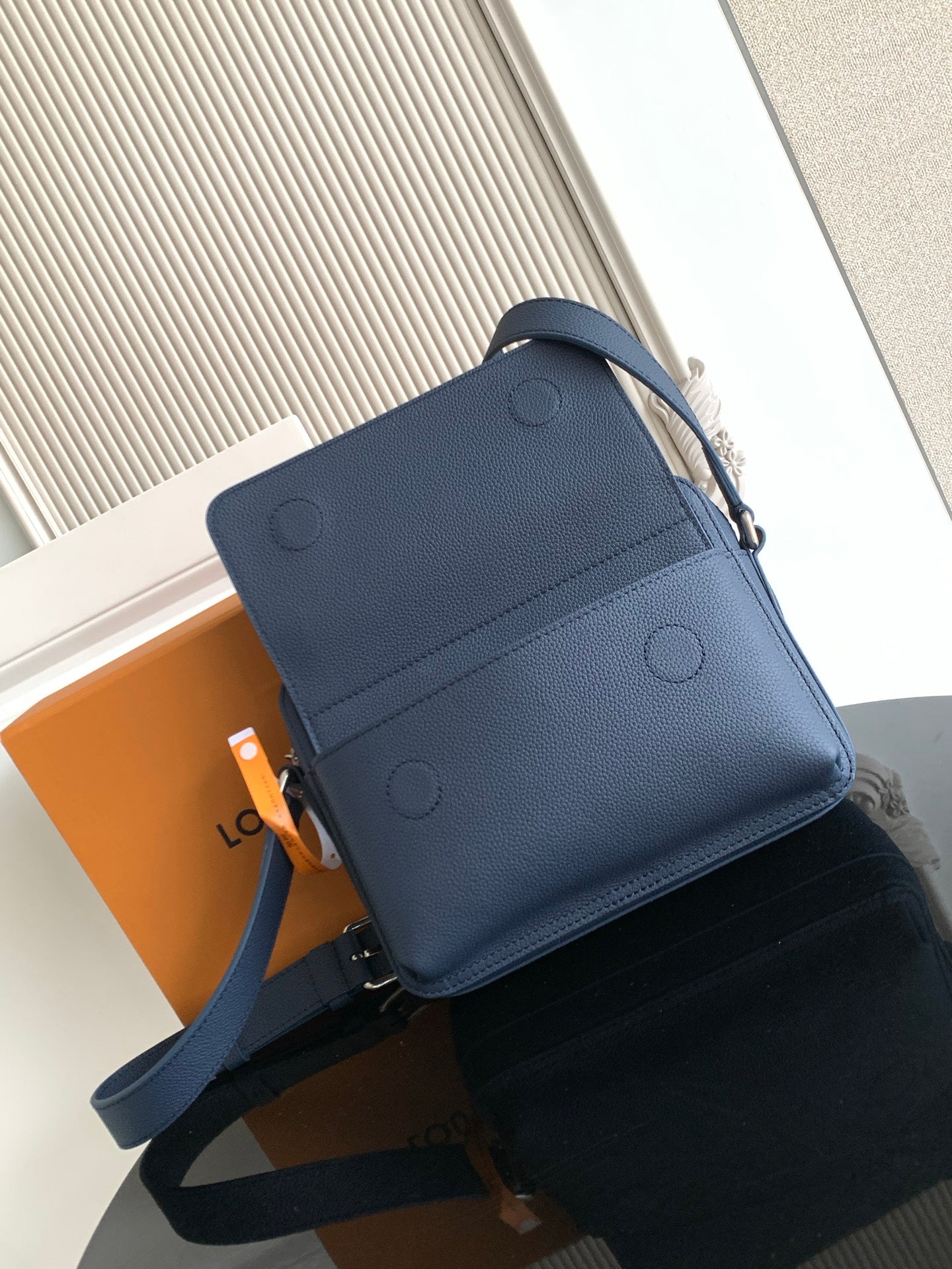 Men's Louis Vuitton blue crossbody bag with embossed front circles and adjustable strap