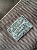 Men's Louis Vuitton light blue leather tag with embossed logo on fabric