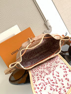 Louis Vuitton monogram mini bag open, showing red patterned lining and tan leather trim.