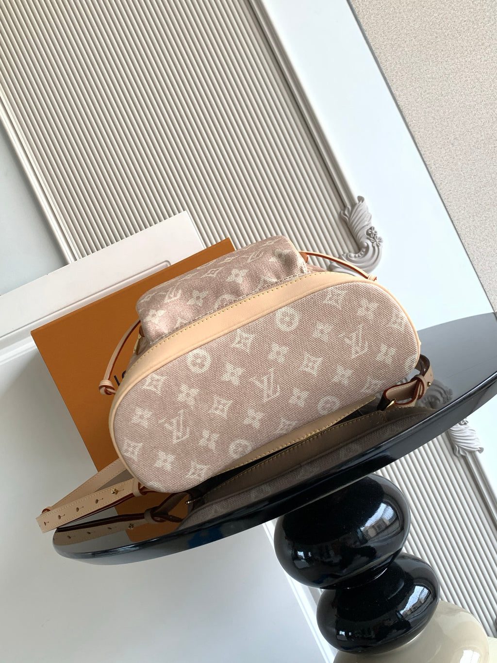 Louis Vuitton monogram mini pouch bag in tan canvas with rounded shape and top handle.