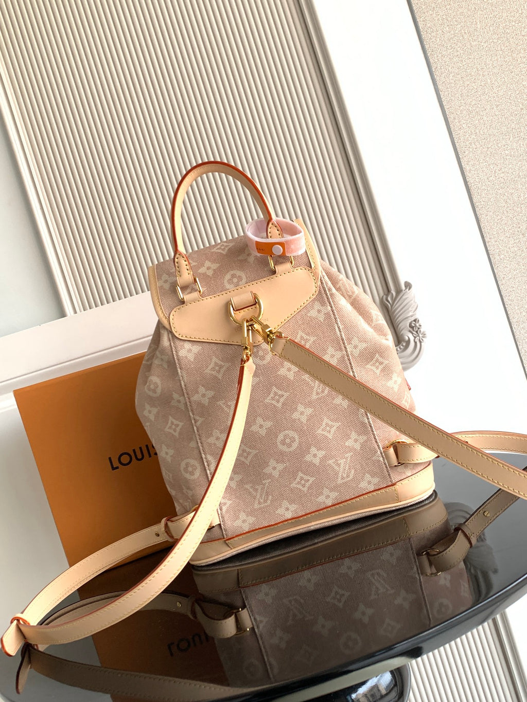 Louis Vuitton monogram mini backpack front view, tan canvas, top handle, and crossbody strap.