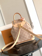 Louis Vuitton monogram mini backpack front view, tan canvas, top handle, and crossbody strap.