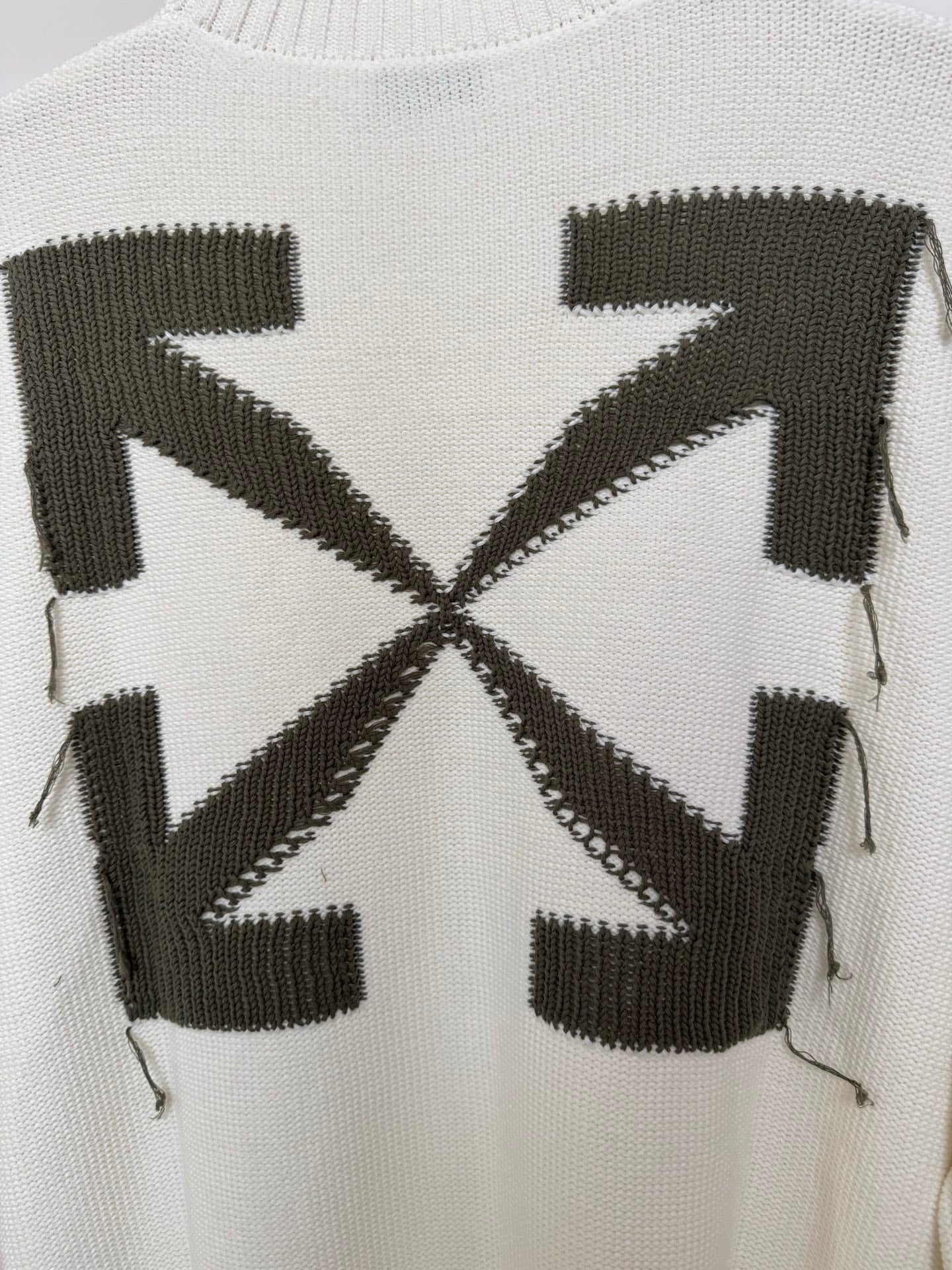 Off-white sweater back close-up with black geometric block and cross motif