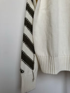 Off-white sweater with black diagonal stripe-knit panel on one sleeve