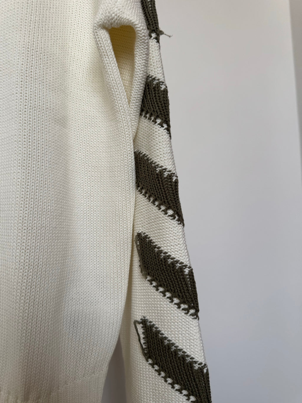 Off-white sweater sleeve with black diagonal stripe-knit detail