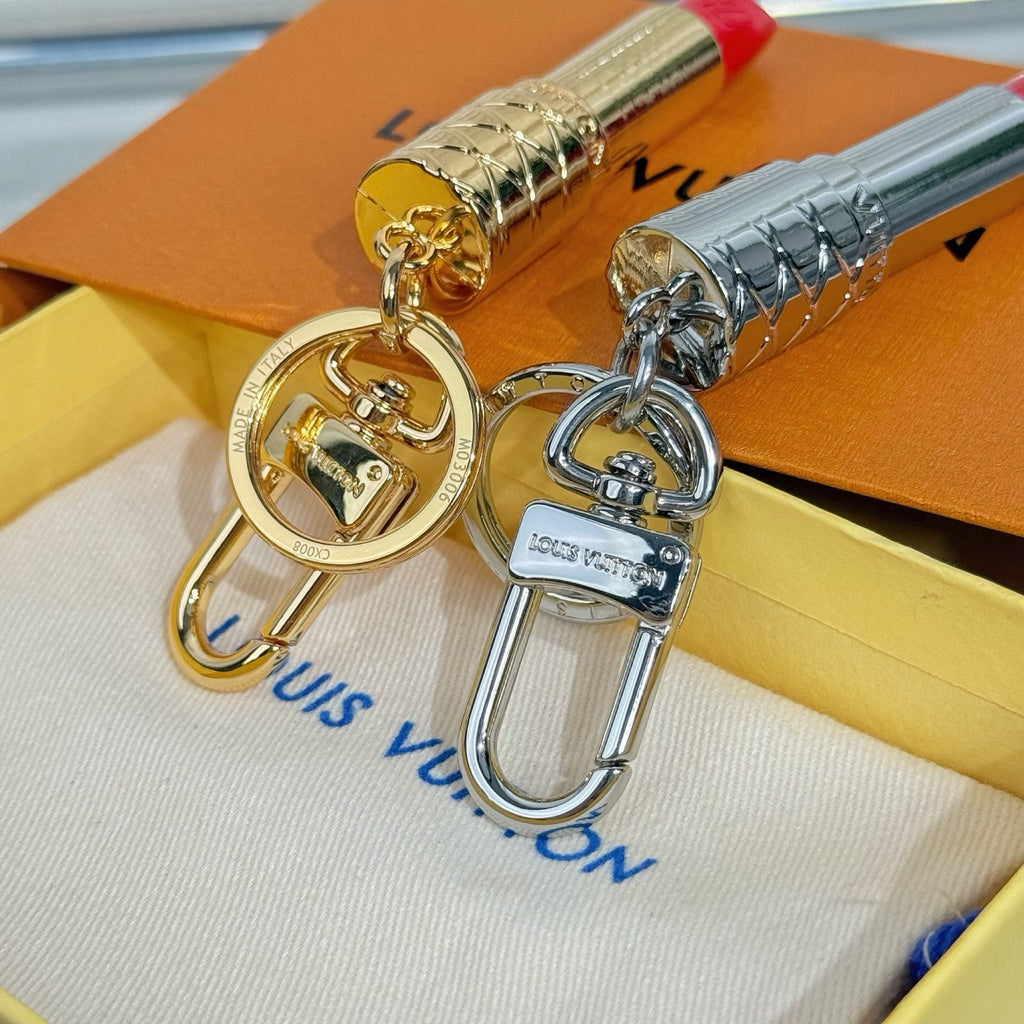 Small bag charm pair with gold and silver lipstick pendants, circular keyring clasp hardware