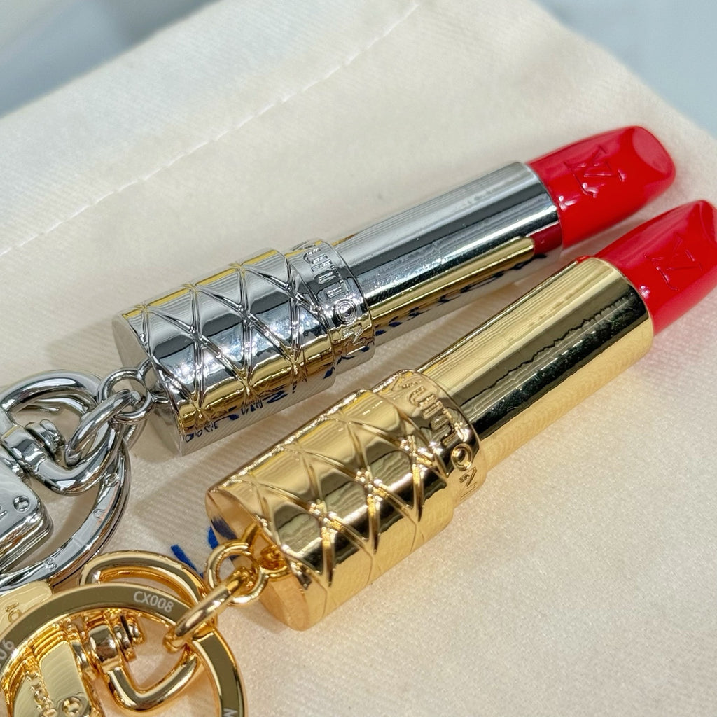 Small bag charm with silver and gold lipstick pendants on fabric pouch, metal rings