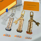 Louis Vuitton keychains with lock charms and patterned straps, silver and gold tones