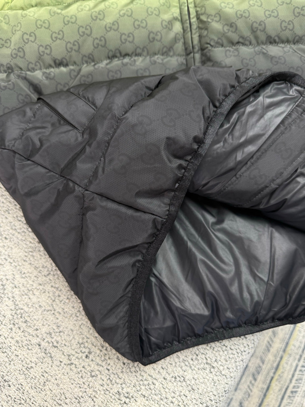 Dark gray puffer jacket with allover GG logo texture and padded quilting
