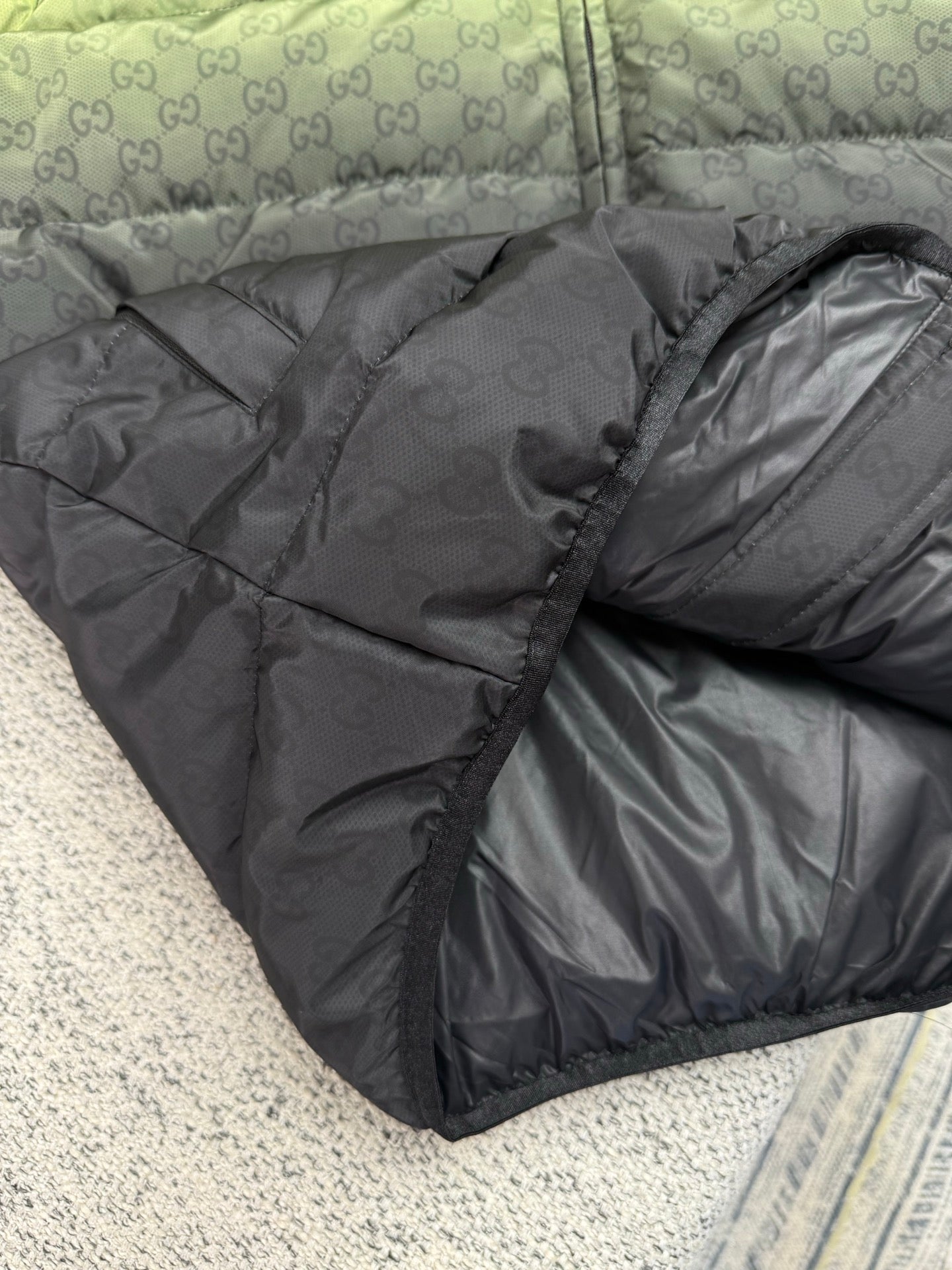 Dark gray puffer jacket with allover GG logo texture and padded quilting