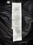 GUCCI clothing care label on black padded jacket, with size and fabric info