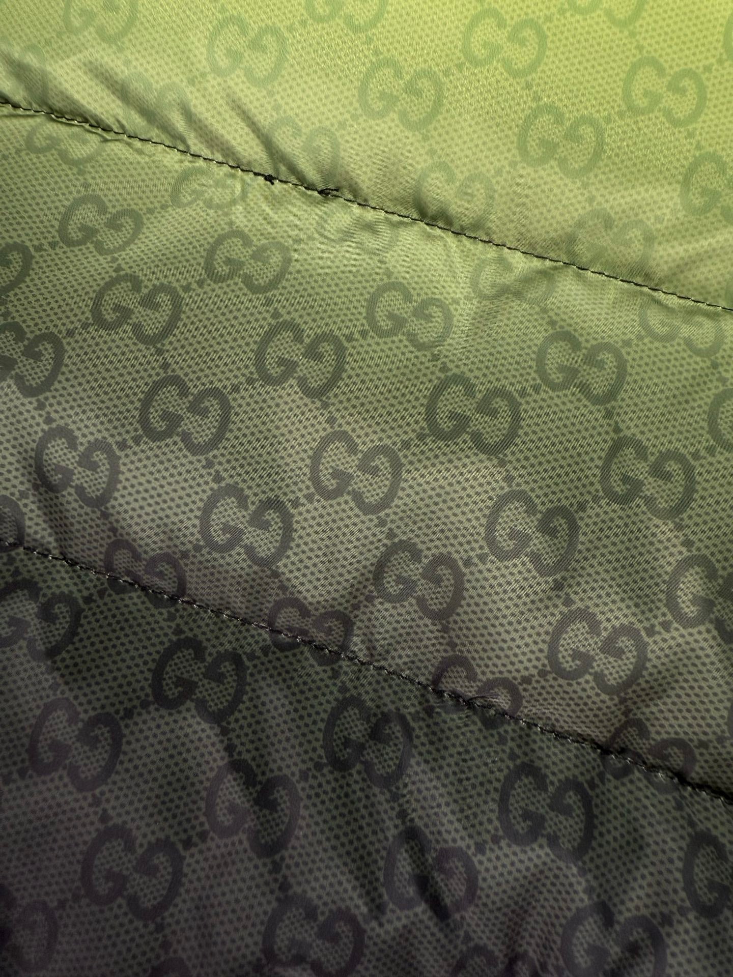 Two-tone puffer jacket panel with lime green and dark GG logo pattern