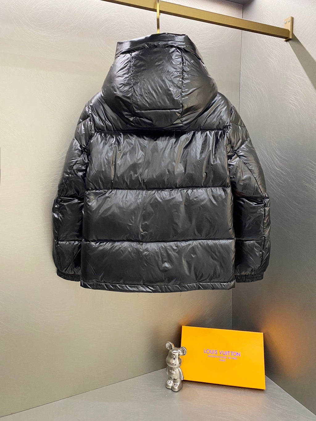 Moncler long padded jacket back view with hood and dark quilted paneling