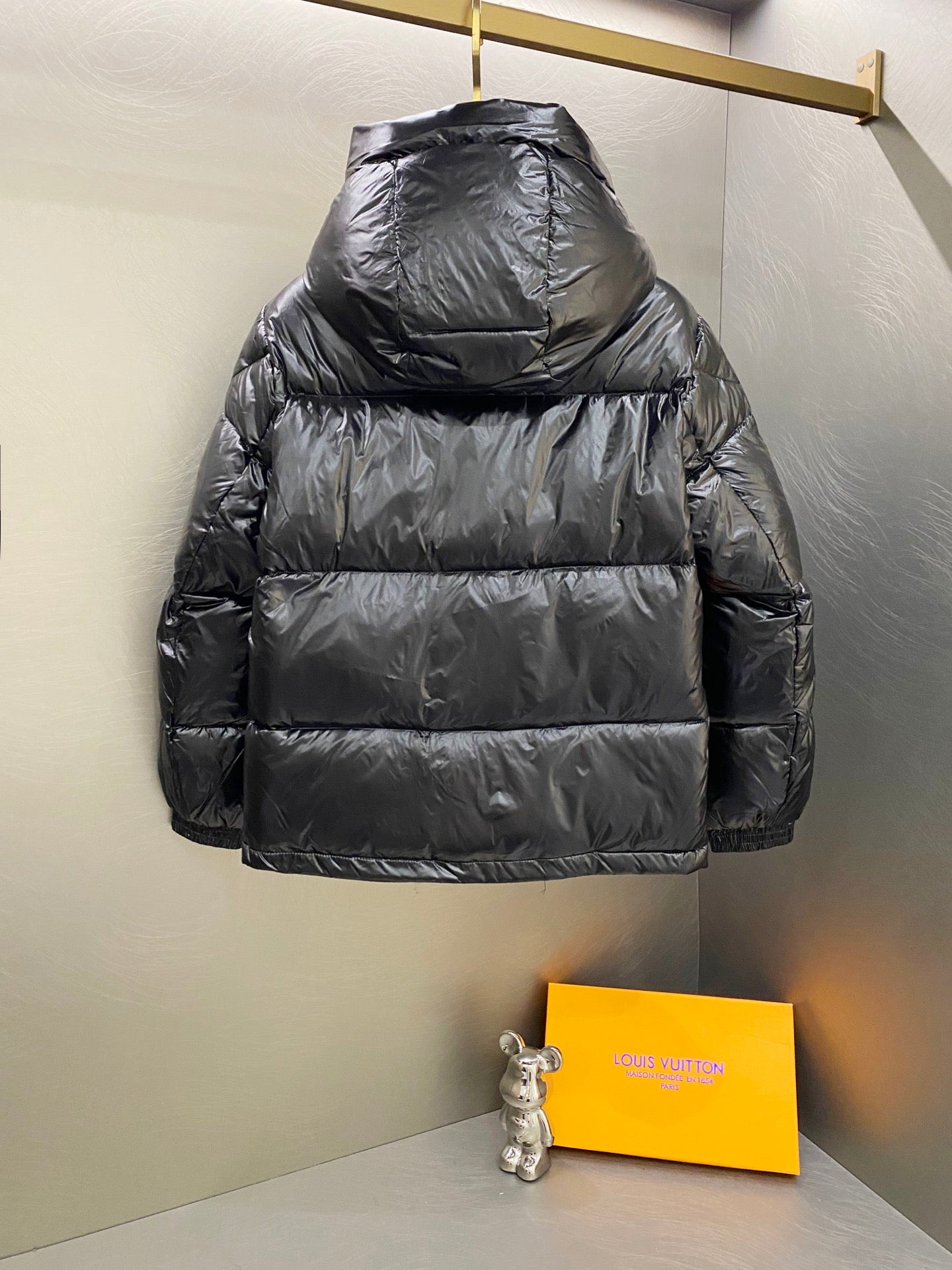 Moncler long padded jacket back view with hood and dark quilted paneling