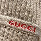 Beige ribbed knit cardigan hem label with red and black logo