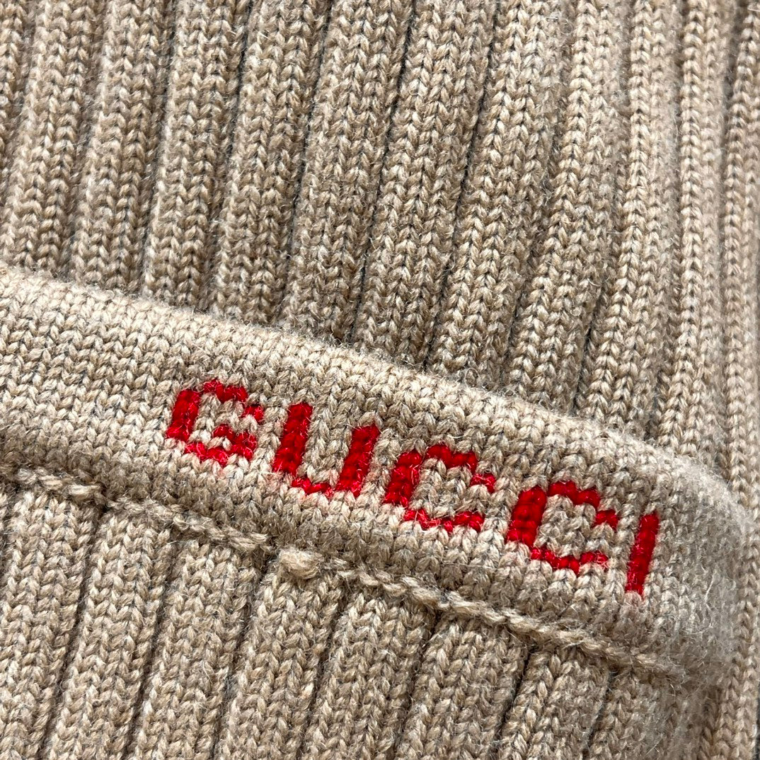Beige ribbed knit cardigan hem label with red and black logo