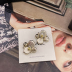Chanel-style charm earrings on white card, gold-tone flowers with pearl and sparkly stones