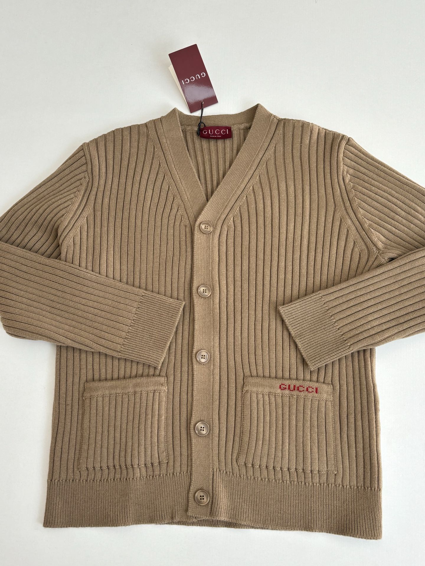 Tan ribbed knit cardigan with V-neck, button front, and Gucci logo patch