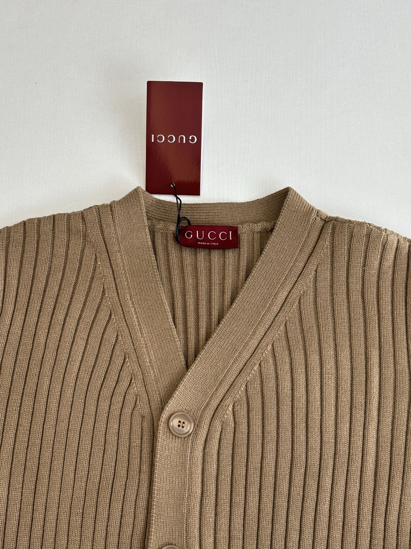 Tan ribbed knit V-neck cardigan with button placket and Gucci logo tag